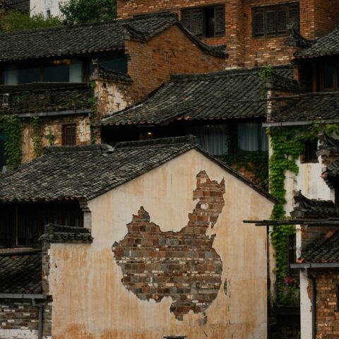 An old building with a map of China on the side of it.