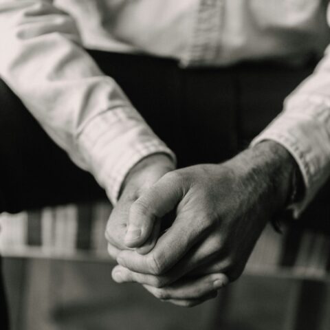 A person with clasped hands praying.