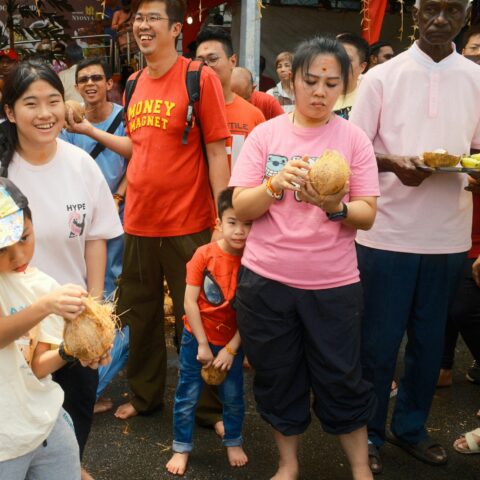 An ethnically diverse group of people at an outdoor market in Malaysia.