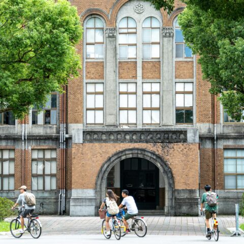 A group of students riding bikes in front of National Taiwan University.